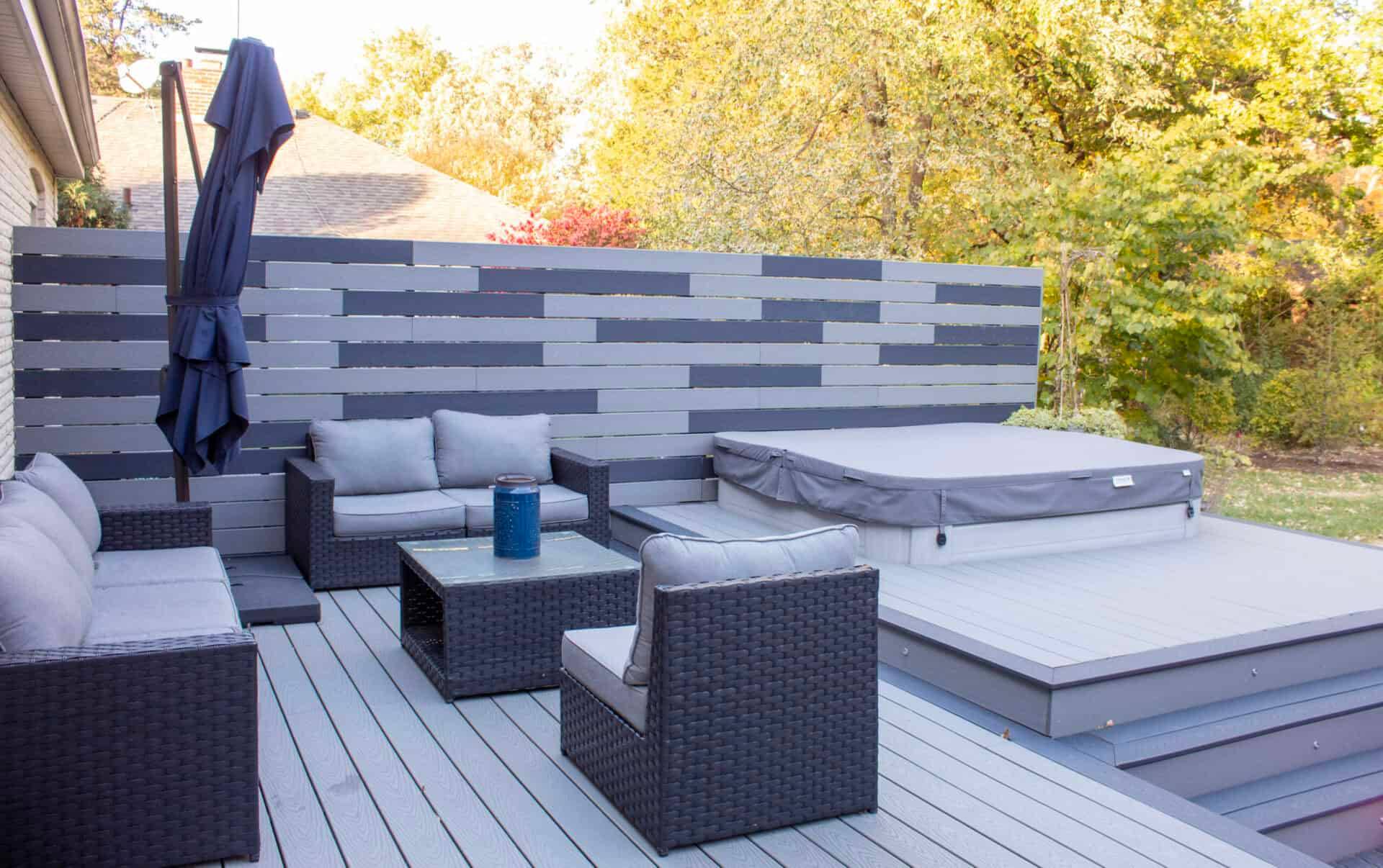 Composite deck with a hot tub, privacy screen and lounge seating