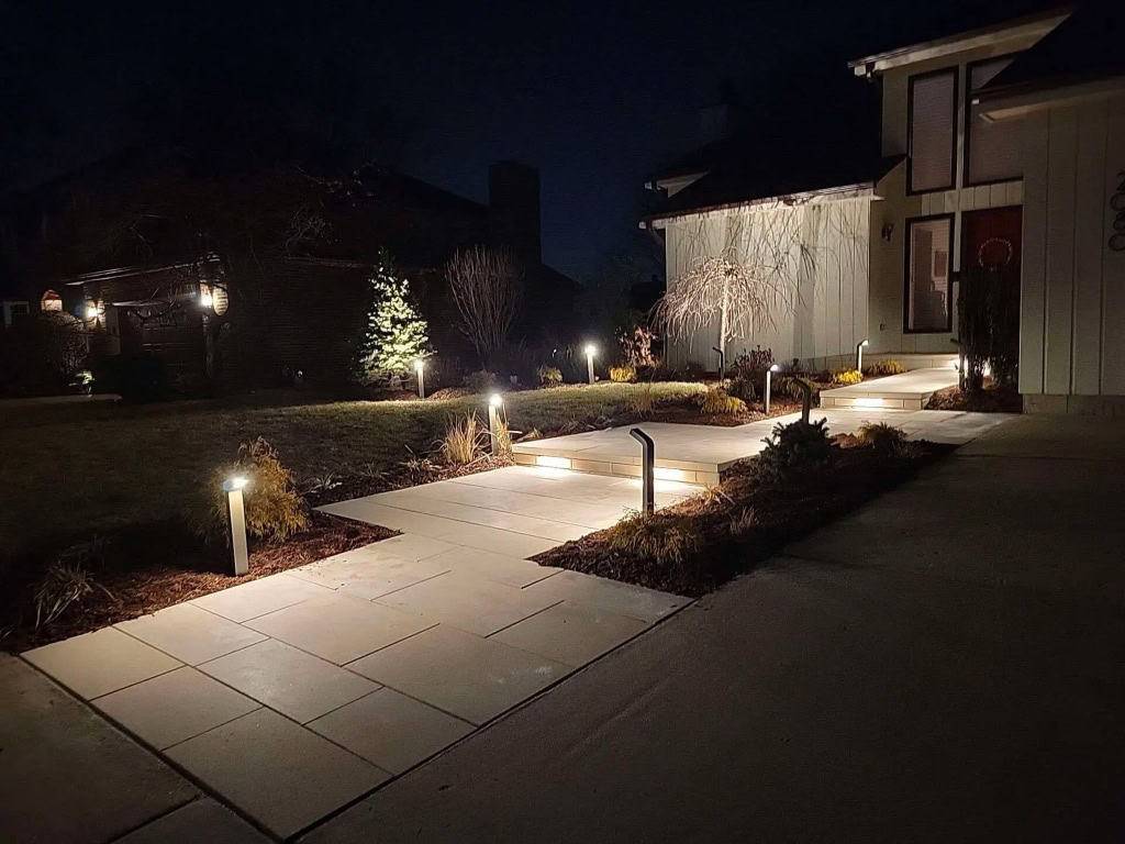 Front walkway lined with low bollard and step lighting at night