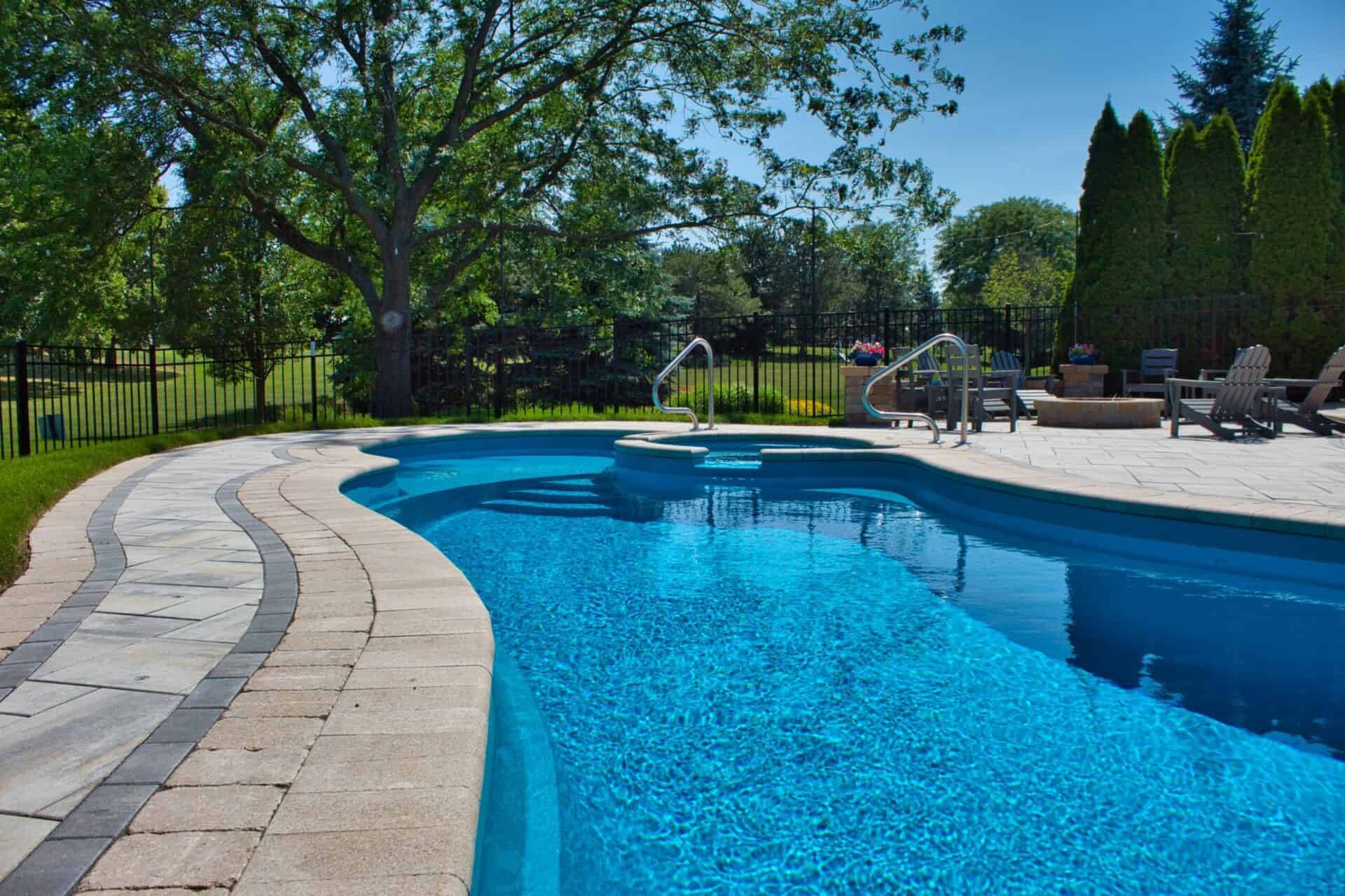 In-ground pool with a paver deck set into a large landscaped lot in Chicago's Northwest suburbs